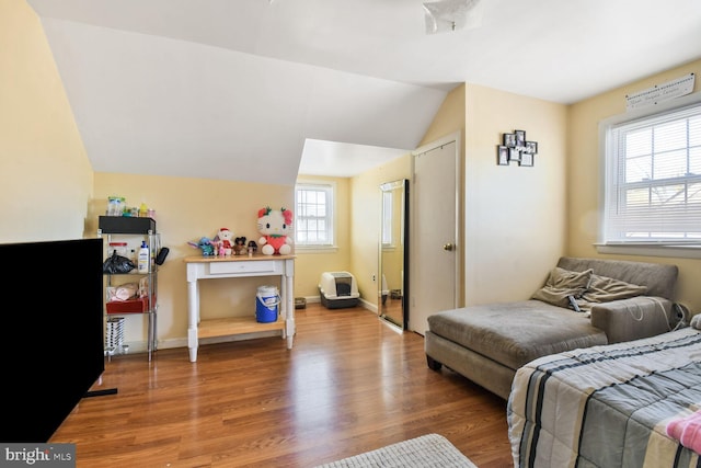 bedroom with lofted ceiling, baseboards, and wood finished floors