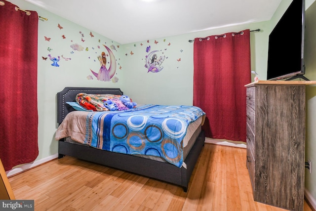 bedroom with baseboards and wood finished floors