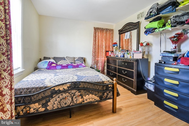 bedroom featuring wood finished floors and visible vents