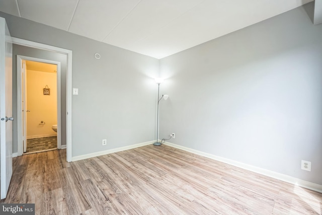 spare room featuring light wood-style floors and baseboards