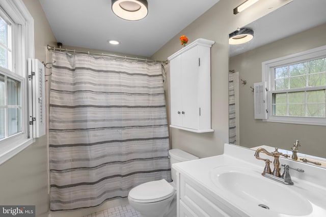bathroom featuring toilet, a shower with shower curtain, and vanity