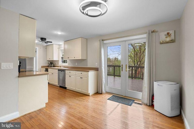 kitchen featuring light wood finished floors, french doors, dishwasher, and baseboards