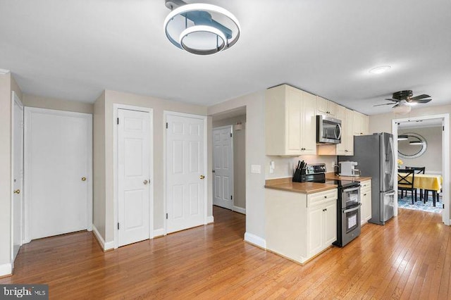 kitchen with light wood-type flooring, appliances with stainless steel finishes, ceiling fan, and baseboards