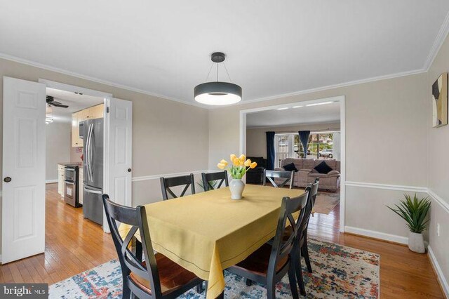 dining room with light wood-style floors, baseboards, and ornamental molding