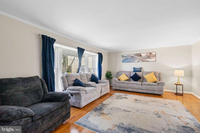 living area with light wood-style floors, baseboards, and crown molding