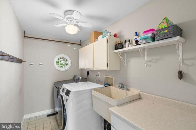 laundry area featuring baseboards, washing machine and dryer, cabinet space, ceiling fan, and a sink
