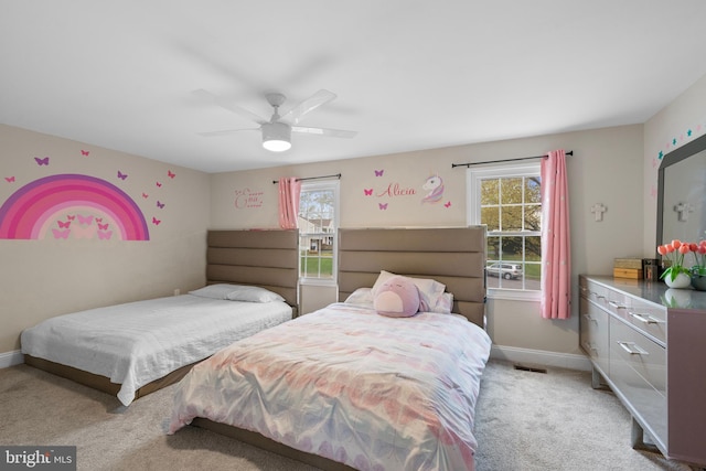 bedroom with light carpet, visible vents, baseboards, and ceiling fan