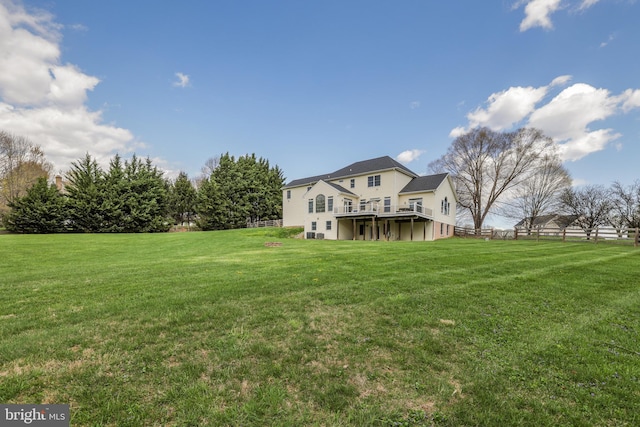 rear view of property featuring a wooden deck and a yard