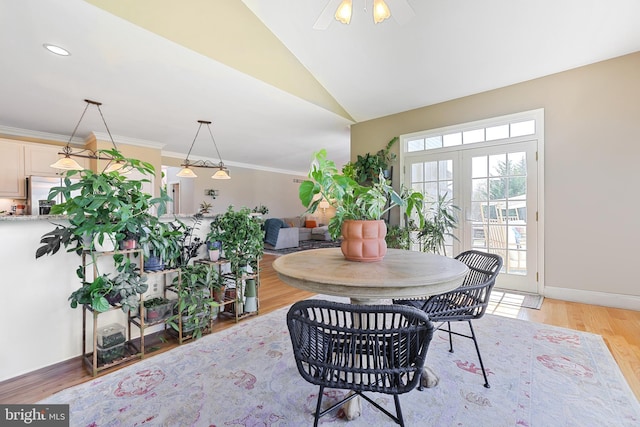 dining space with vaulted ceiling, a ceiling fan, light wood finished floors, and baseboards