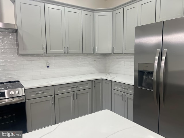 21 Piute Trl, Albrightsville, PA 18210 - kitchen featuring stainless steel appliances, gray cabinetry, decorative backsplash, light stone counters, and wall chimney exhaust hood