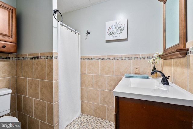 bathroom with vanity, a shower with shower curtain, and tile walls