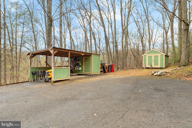view of vehicle parking with a storage shed, a carport, and driveway