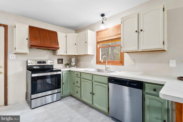kitchen with green cabinets, white cabinetry, light countertops, a sink, and stainless steel appliances