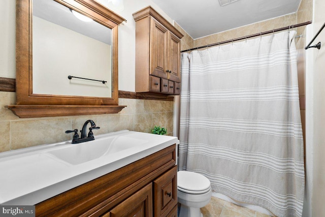 bathroom featuring toilet, vanity, a shower with shower curtain, and tile walls