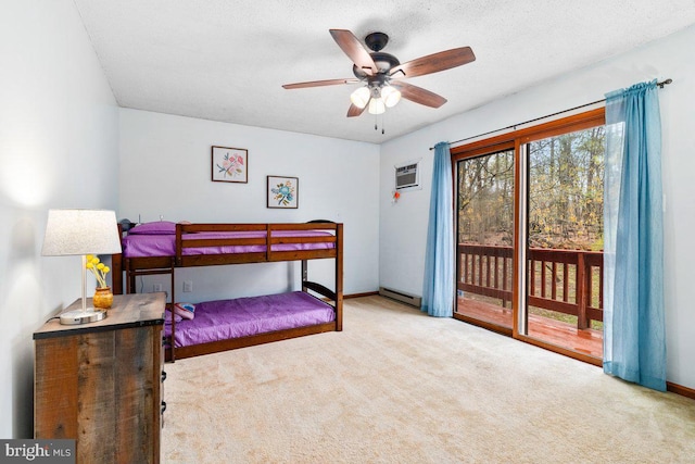 carpeted bedroom featuring baseboards, a wall mounted air conditioner, a baseboard radiator, a ceiling fan, and access to exterior