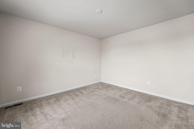 carpeted empty room featuring visible vents and baseboards