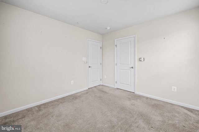 empty room featuring carpet flooring and baseboards