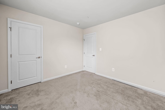 unfurnished bedroom featuring carpet flooring and baseboards