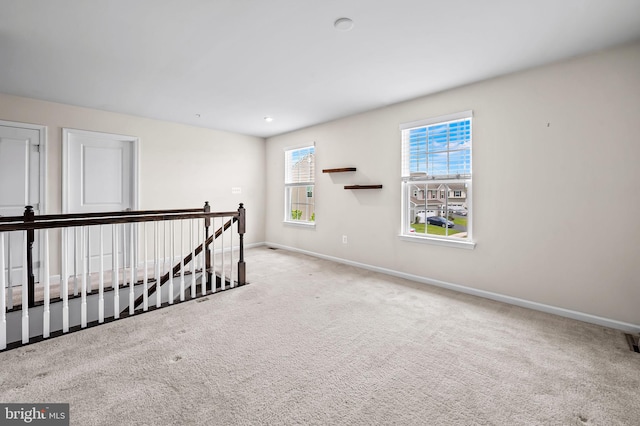 carpeted empty room with visible vents and baseboards