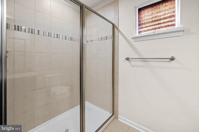 bathroom with a stall shower and baseboards