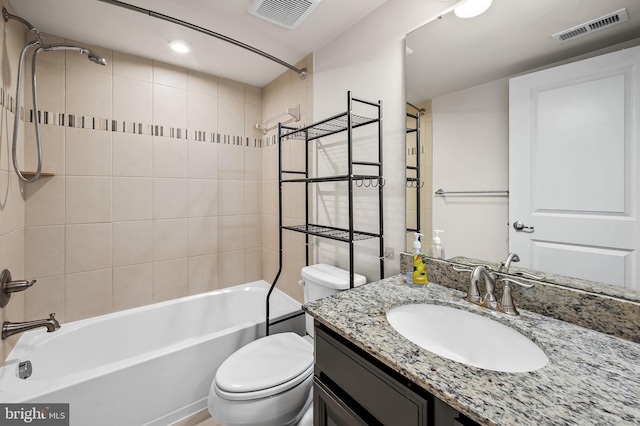 bathroom with visible vents, toilet, vanity, and shower / washtub combination