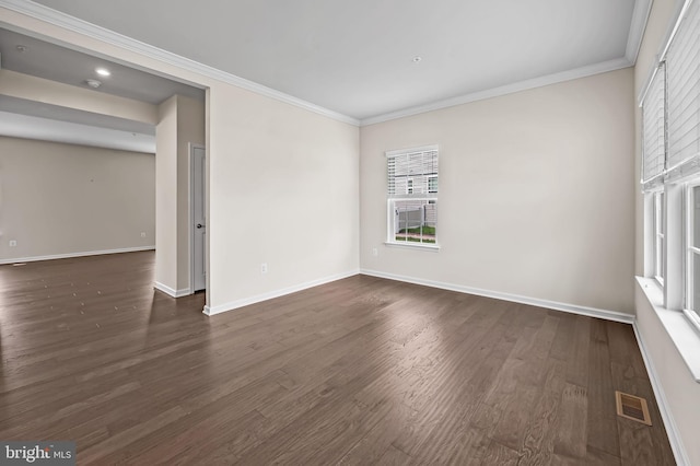 unfurnished room with ornamental molding, baseboards, dark wood finished floors, and visible vents