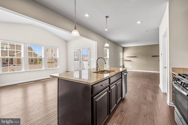 kitchen featuring dark wood-style flooring, baseboards, open floor plan, stainless steel appliances, and a sink