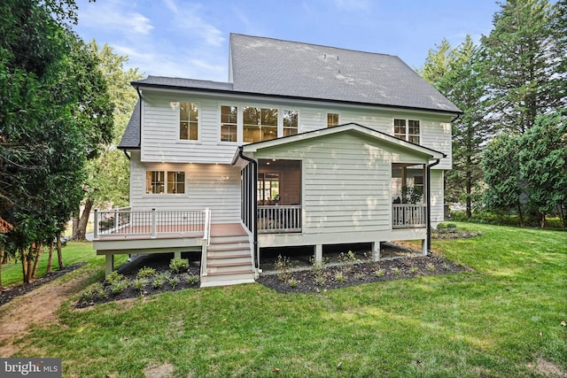 back of house with a wooden deck, roof with shingles, and a yard