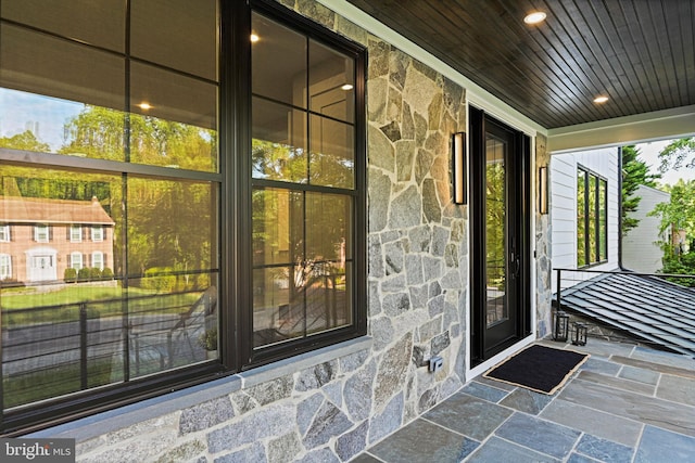 property entrance with stone siding and covered porch