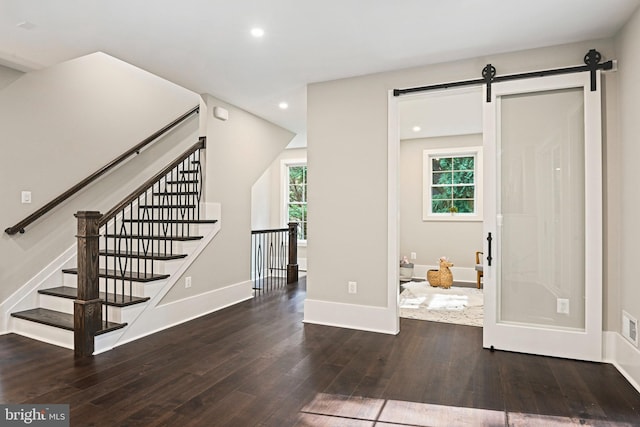 interior space with a barn door, a wealth of natural light, hardwood / wood-style flooring, and recessed lighting