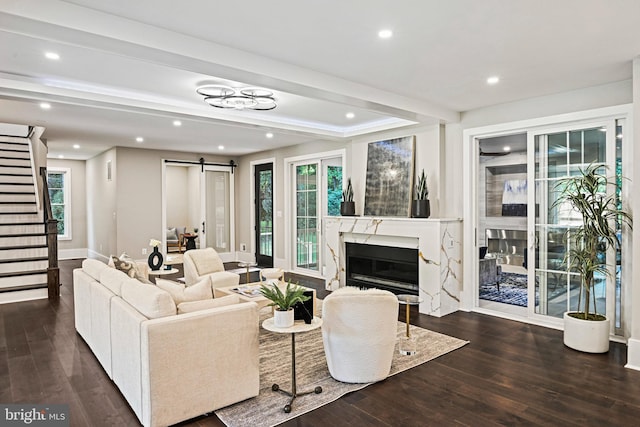 living area featuring a barn door, recessed lighting, stairway, wood finished floors, and a fireplace