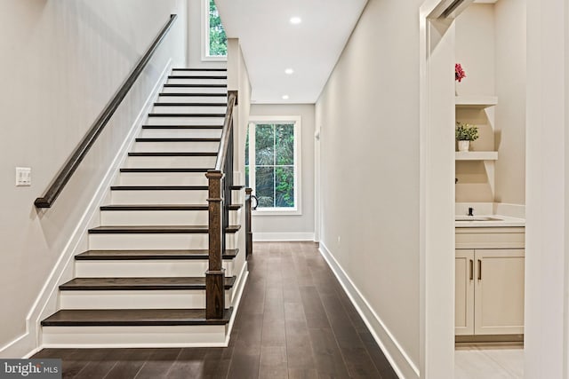 stairs with recessed lighting, wood finished floors, and baseboards