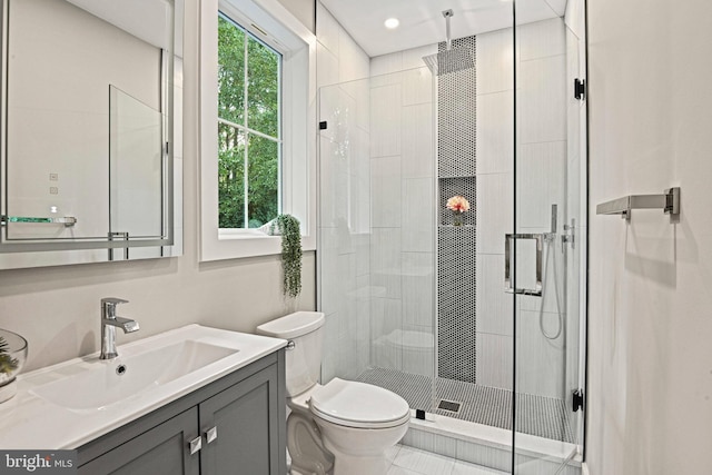 bathroom featuring toilet, vanity, and a stall shower