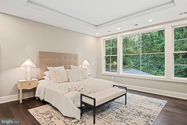 bedroom with visible vents, a tray ceiling, and multiple windows