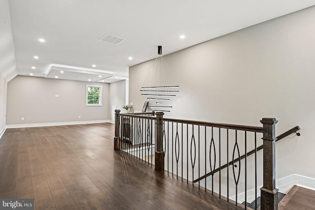 hallway featuring recessed lighting, wood finished floors, visible vents, and an upstairs landing