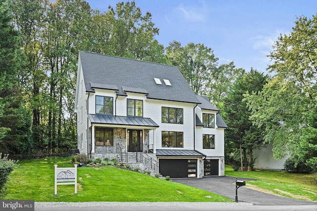 modern inspired farmhouse featuring stone siding, an attached garage, a porch, roof with shingles, and a front yard