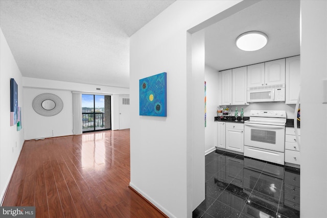200 N Pickett St N Unit 1513, Alexandria, VA 22304 - kitchen with dark countertops, baseboards, white cabinetry, and white appliances
