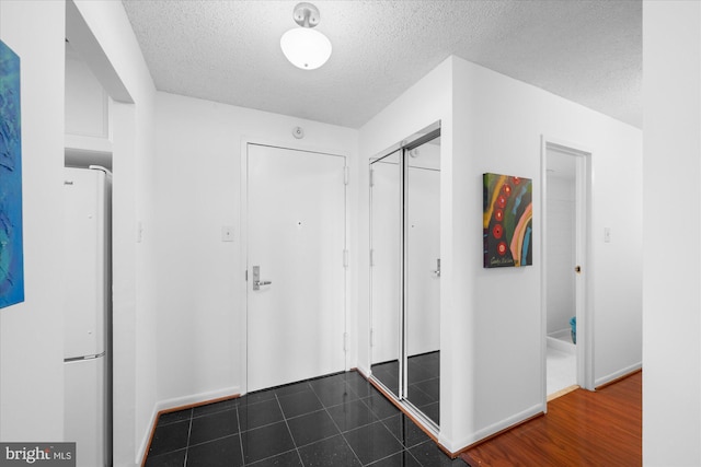 200 N Pickett St N Unit 1513, Alexandria, VA 22304 - hallway with dark tile patterned flooring, baseboards, and a textured ceiling