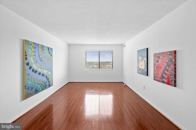 200 N Pickett St N Unit 1513, Alexandria, VA 22304 - unfurnished room featuring baseboards, wood finished floors, and a textured ceiling
