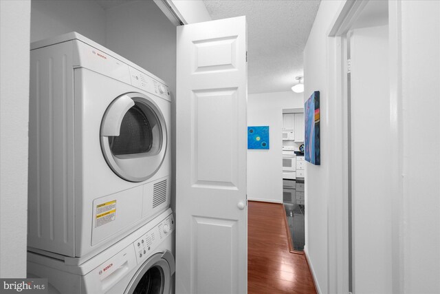 200 N Pickett St N Unit 1513, Alexandria, VA 22304 - laundry room featuring a textured ceiling, dark wood-style flooring, baseboards, stacked washer / dryer, and laundry area
