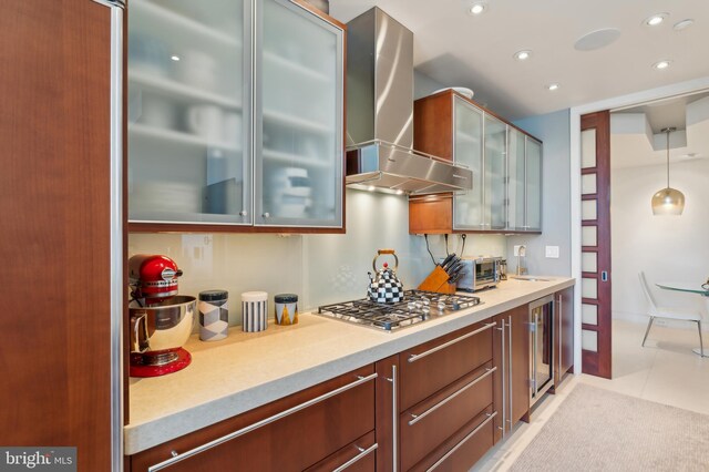 1612 16th St NW Unit 3, Washington, DC 20009 - kitchen featuring stainless steel gas cooktop, wall chimney exhaust hood, recessed lighting, light countertops, and glass insert cabinets