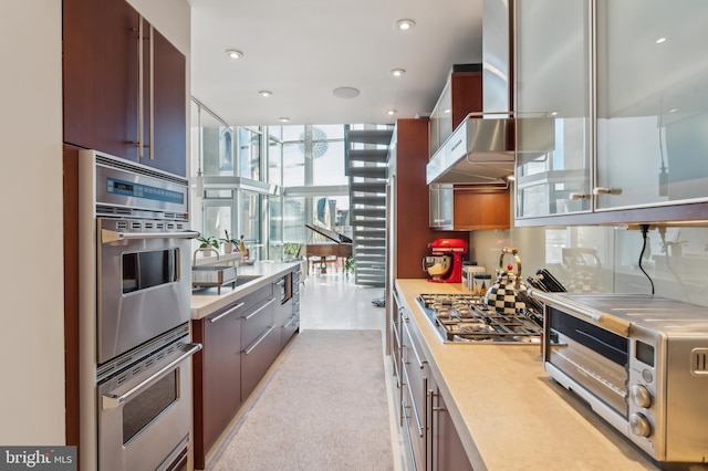 1612 16th St NW Unit 3, Washington, DC 20009 - kitchen with appliances with stainless steel finishes, light countertops, modern cabinets, wall chimney exhaust hood, and recessed lighting
