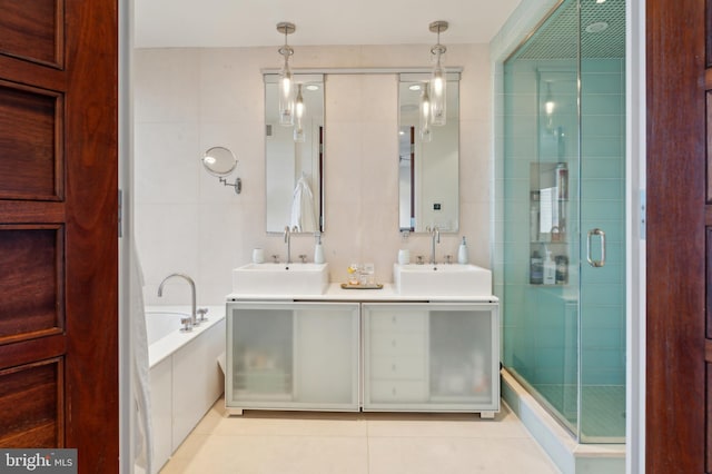 1612 16th St NW Unit 3, Washington, DC 20009 - full bathroom featuring tile patterned floors, double vanity, a stall shower, a bath, and tile walls