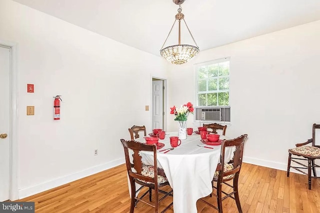 24171 Adelaide St, Parksley, VA 23421 - dining area featuring baseboards, cooling unit, light wood-style floors, and an inviting chandelier