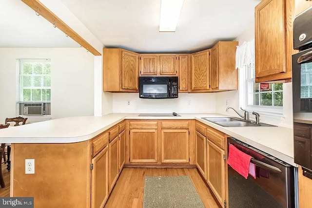 24171 Adelaide St, Parksley, VA 23421 - kitchen with light countertops, a sink, light wood-style floors, a peninsula, and black appliances