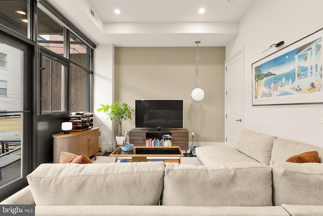 living room with baseboards, recessed lighting, and visible vents