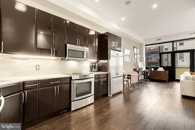 kitchen with light countertops, tasteful backsplash, stainless steel appliances, and dark wood finished floors