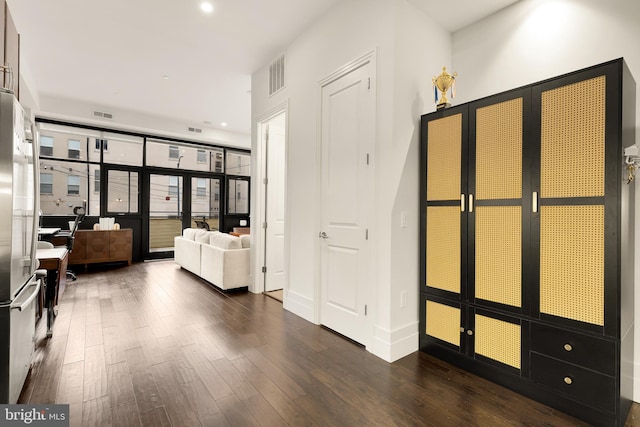 hall with recessed lighting, dark wood finished floors, and visible vents