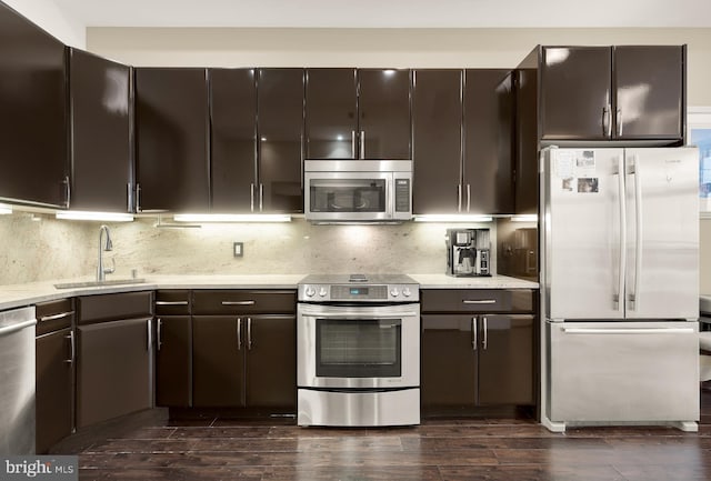 kitchen featuring a sink, backsplash, dark brown cabinetry, and stainless steel appliances