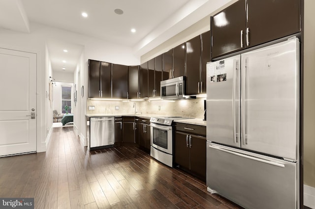 kitchen featuring dark brown cabinetry, dark wood-style floors, recessed lighting, backsplash, and stainless steel appliances